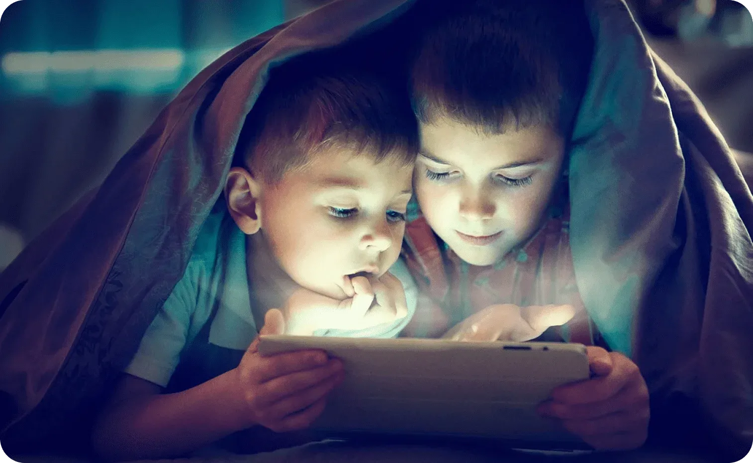 Little brothers playing on a tablet during bedtime Little brothers playing on a tablet during bedtime