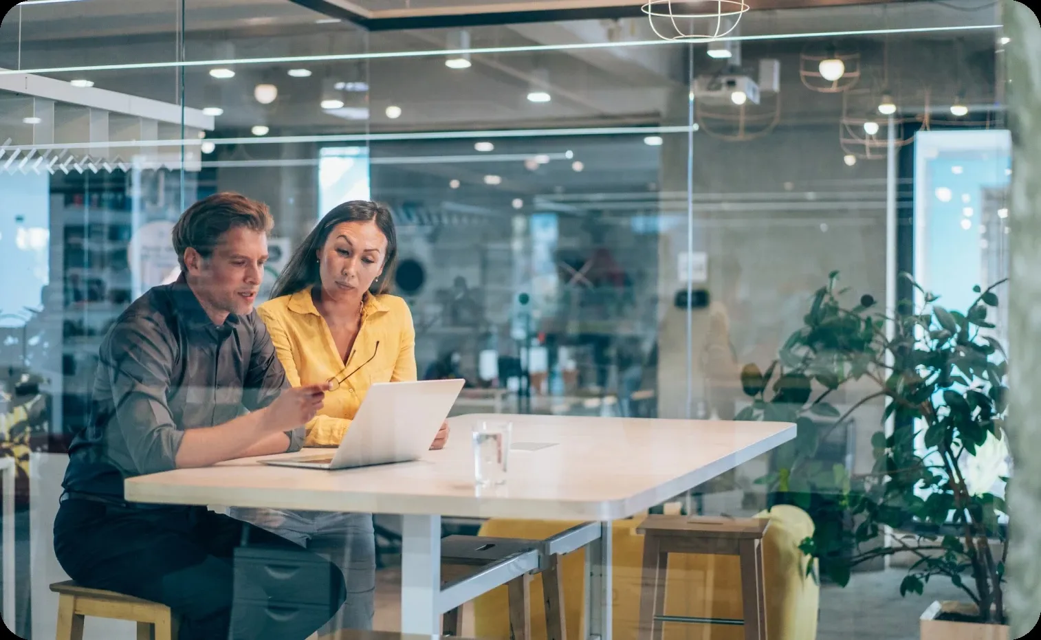 Colleagues having a meeting inside a modern glass walls office Colleagues having a meeting inside a modern glass walls office