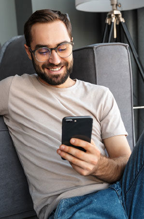 Smiling man sit relaxed while browsing his cellphone Smiling man sit relaxed while browsing his cellphone
