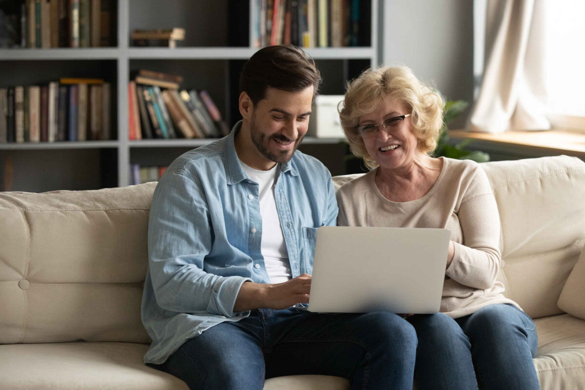 A young man and an elderly lady sit together on a sofa looking at a laptop. The image illustrates a blog about a healthcare leader saving 1.8M with an AI-powered omnichannel strategy. A young man and an elderly lady sit together on a sofa looking at a laptop. The image illustrates a blog about a healthcare leader saving 1.8M with an AI-powered omnichannel strategy.