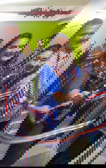 Celebrating the opening of a building with 3 people, cutting the ribbon to indicate something has newly opened Celebrating the opening of a building with 3 people, cutting the ribbon to indicate something has newly opened