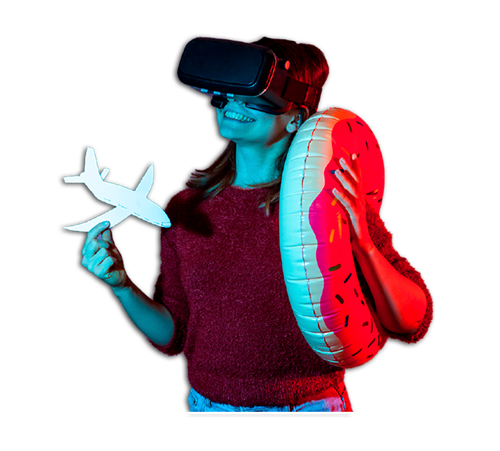 Person wearing VR headset holding a toy plane and inflatable, under blue and red lights. Person wearing VR headset holding a toy plane and inflatable, under blue and red lights.